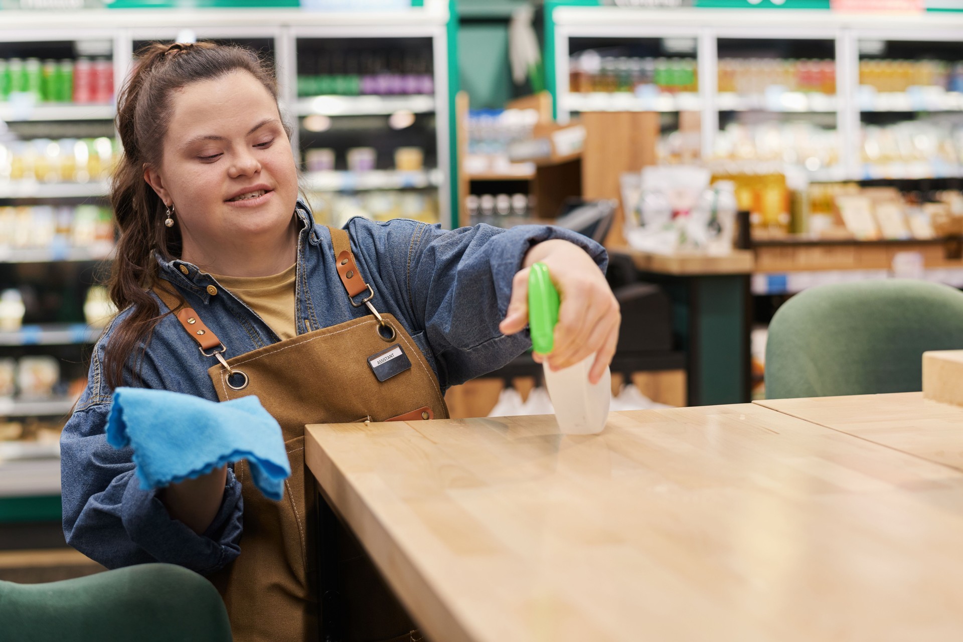 Girl with Disability Sanitizing Tables in Cafe